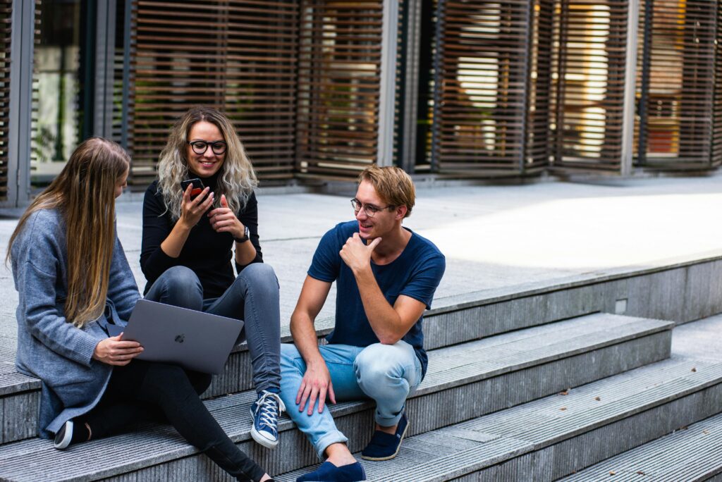 pexels-photo-1438072-1438072 Three young professionals having a friendly chat while sitting on outdoor steps.