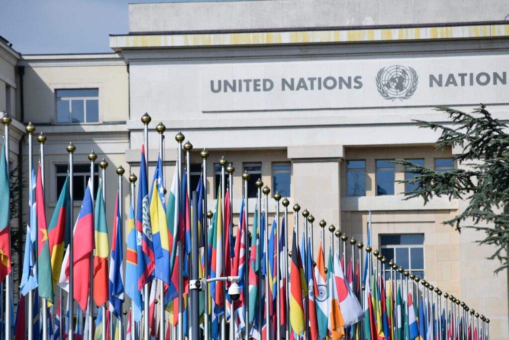pexels-photo-16459372-16459372 Colorful flags outside the United Nations office in Geneva, symbolizing global unity.